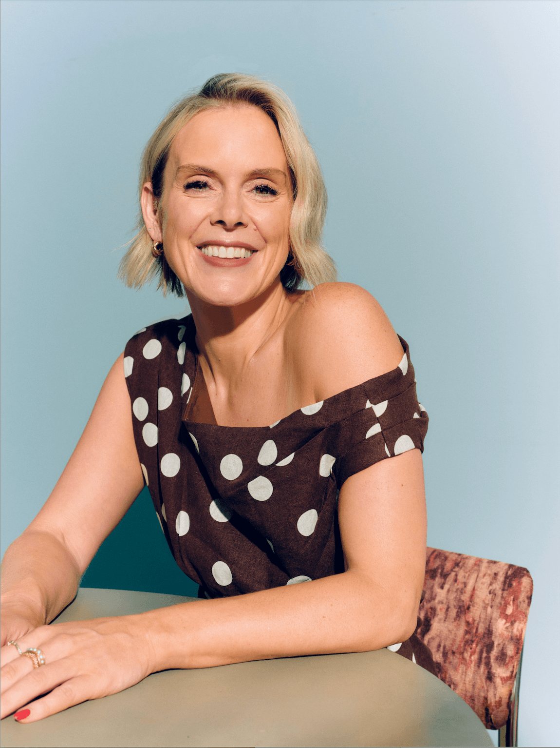 Lauren in a polka dot top sitting at her desk